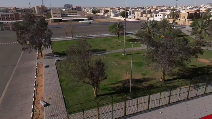 حديقة عامة في حائل مع أشجار والعاب اطفال، لقطة جوية.