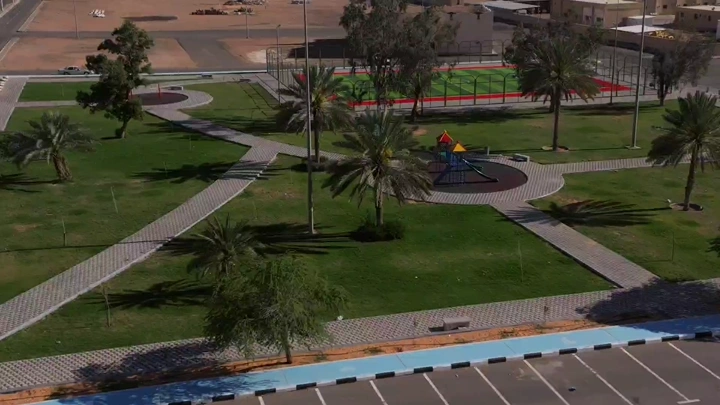 حديقة عامة في حائل مع منطقة ألعاب للأطفال، لقطة جوية.