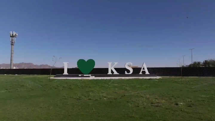لافتة "أحب السعودية" في حديقة خضراء، لقطة نهارية.