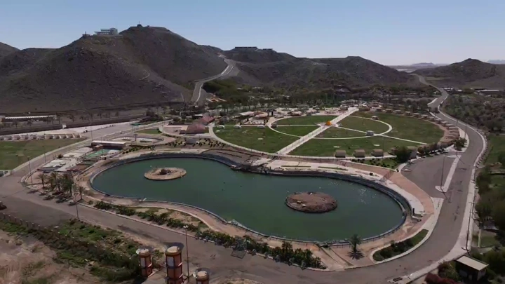 Al Samra Park in Hail with lake and mountains, aerial shot.