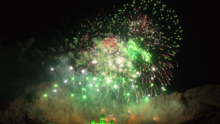 ألعاب نارية خضراء فوق جبل في الليل، لقطة ليلية.