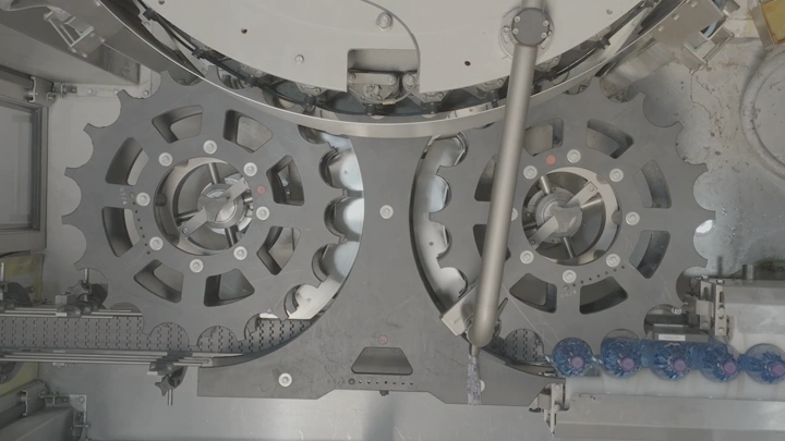 آلات تعبئة علب المياه البلاستيكية في مصنع، لقطة علوية.