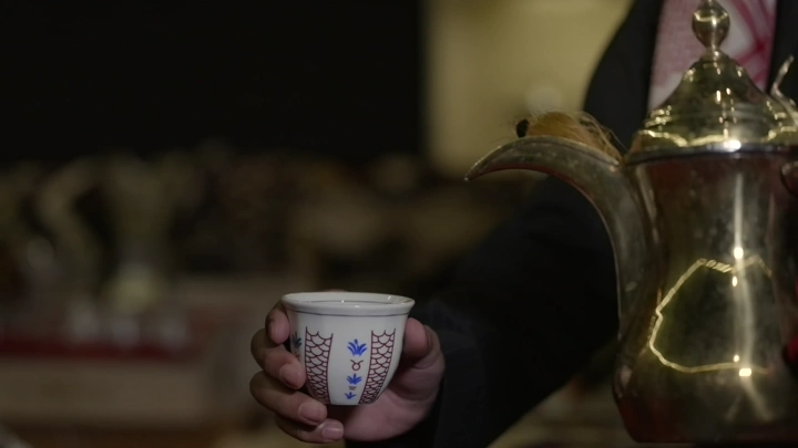 صب القهوة السعودية في فنجان تقليدي، لقطة قريبة.