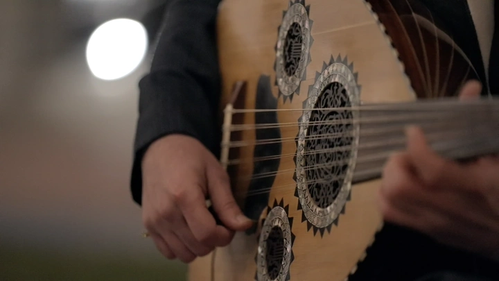 عازف عود يعزف في الليل، لقطة قريبة.