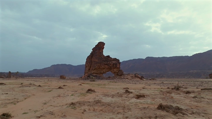 تكوين صخري القوس من جبال المسمى بحائل، لقطة جوية نهارية.