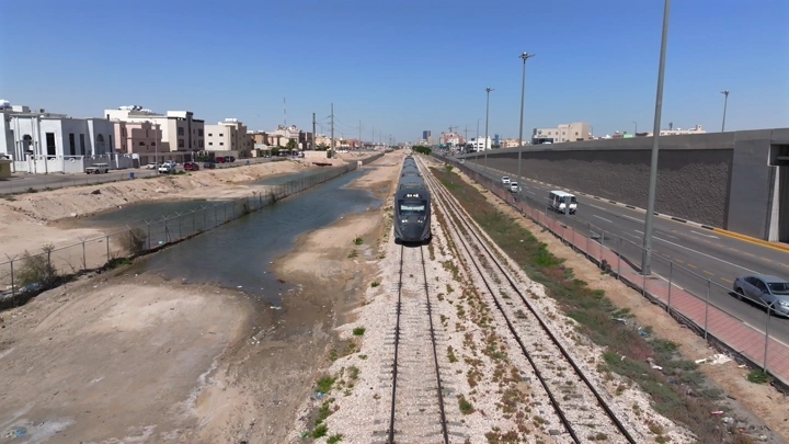 قطار يسير في منطقة حضرية، لقطة جوية أمامية.