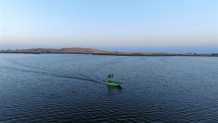 قارب في بحيرة الأصفر يحمل علم السعودية في الحساء، لقطة جوية.