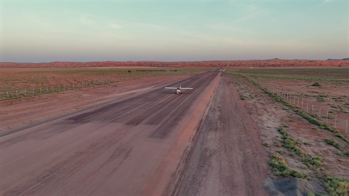 طائرة خاصة على مدرج في الصحراء، لقطة جوية.