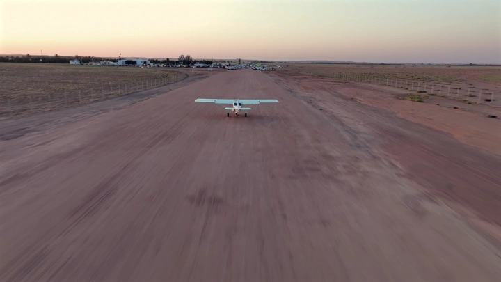 طائرة خاصة على مدرج ترابي عند الغروب، لقطة جوية.