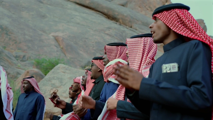 رجال يرتدون الزي التقليدي السعودي في عرضة، لقطة خارجية.