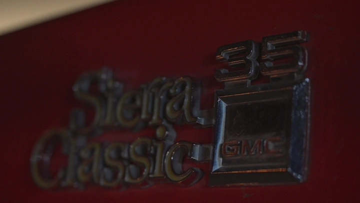 شعار سيارة سيرا كلاسيك 35 على خلفية حمراء، لقطة مقربة.