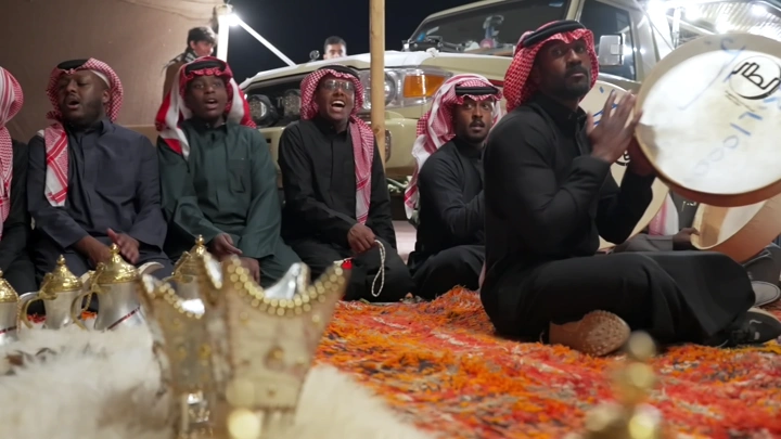 مجموعة رجال يرتدون الزي التقليدي يؤدون السامري في الليل، لقطة قريبة.