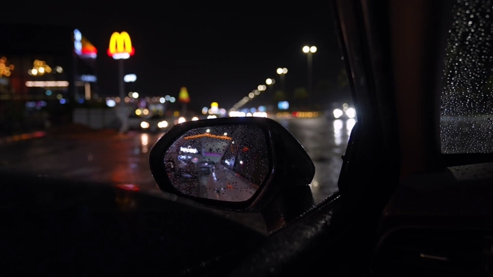 مرآة سيارة في ليلة ممطرة، تصوير ليلي.