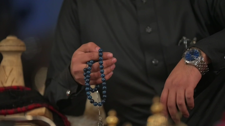 رجل يحمل مسبحة زرقاء في يده، تصوير قريب.