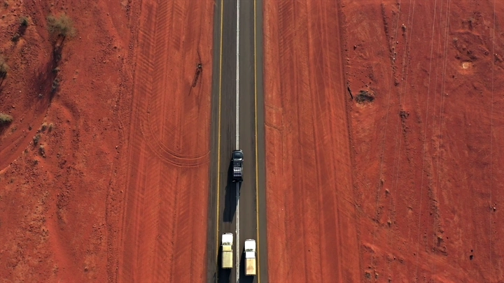 طريق صحراوي مع شاحنة وسيارة من الأعلى، لقطة جوية.