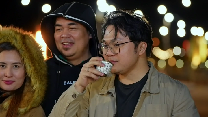 مجموعة من الأشخاص يشربون القهوة في الليل، صورة ليلية.