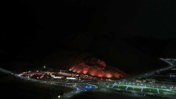 جبل مضاء مع برق ليلاً في المدينة، لقطة جوية.