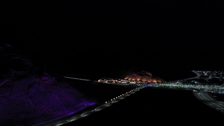 مدينة حائل ليلاً مع برق و الجبال المضيئة، لقطة جوية.