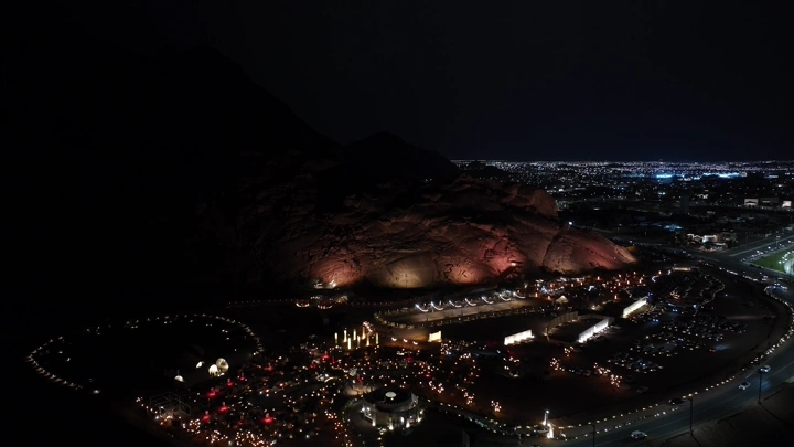 مدينة حائل ليلاً مع برق و الجبال المضيئة، لقطة جوية.