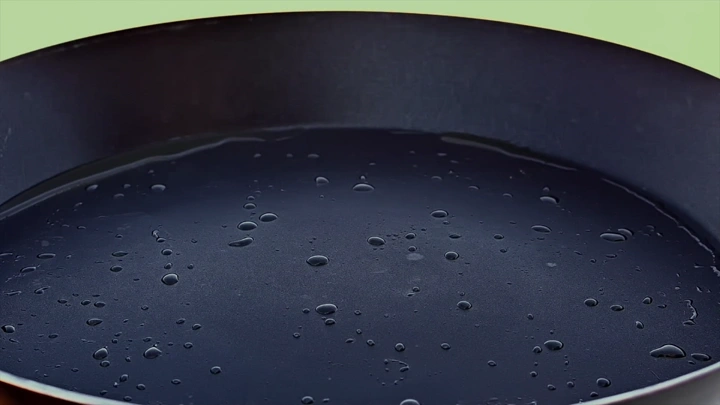 مقلاة سوداء مع قطرات زيت، لقطة مقربة.