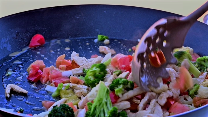طهي الخضار واللحم في مقلاة، لقطة قريبة.