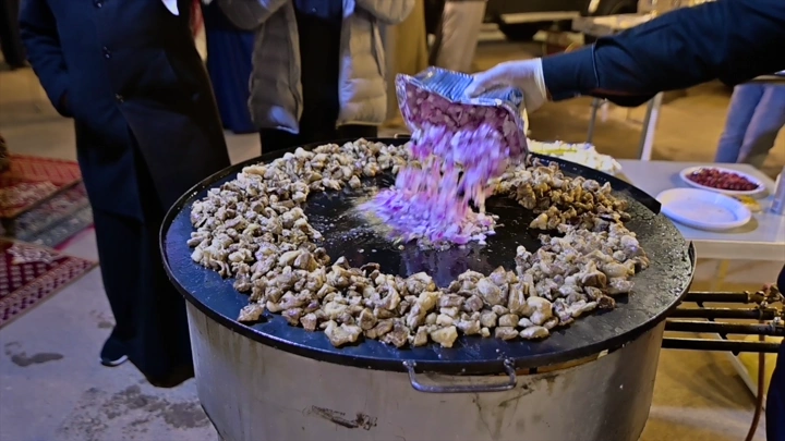 تحضير الطعام في الهواء الطلق ليلاً، لقطة قريبة.