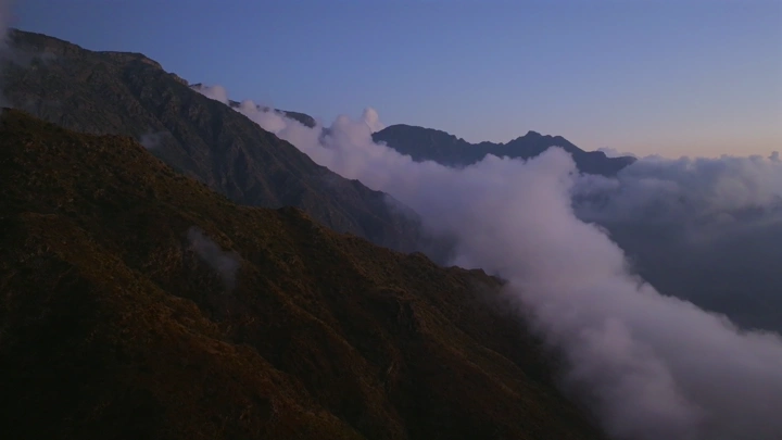 جبال السودة مغطاة بالضباب عند الغروب، لقطة جوية.