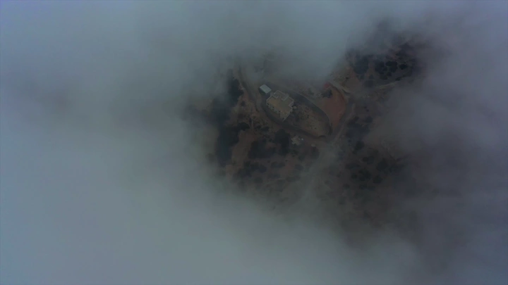 منظر جوي لمبنى محاط بالغيوم في شعف الوليد بالنماص، لقطة درون.