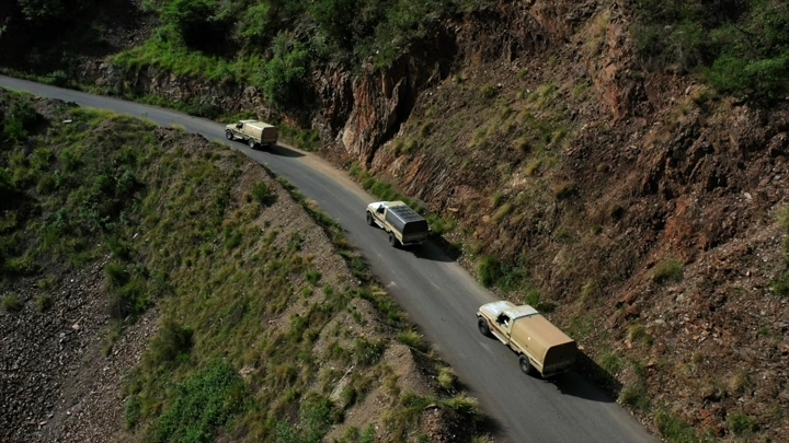 سيارات تسير على طريق جبلي في عسير، لقطة جوية.