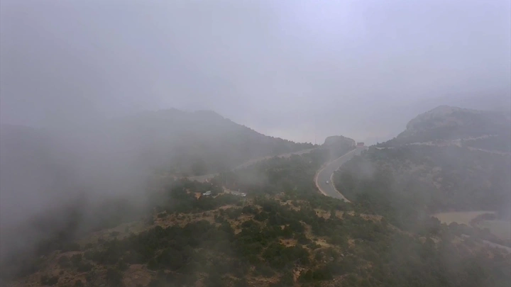 طريق جبلي في شعف الوليد بالنماص مغطى بالضباب، منظر جوي.