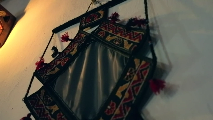 زخرفة تقليدية معلقة على جدار في إضاءة خافتة، لقطة قريبة.