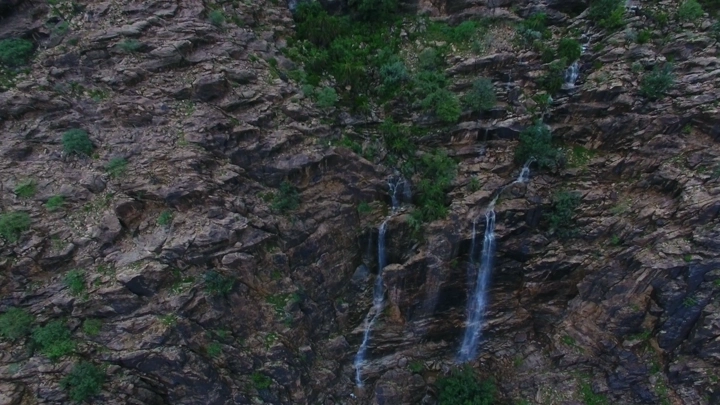 شلالات صغيرة تتدفق على منحدر صخري، لقطة جوية.