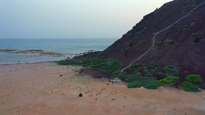 شاطئ وجبل في جزيرة جبل كدمبل، لقطة جوية.