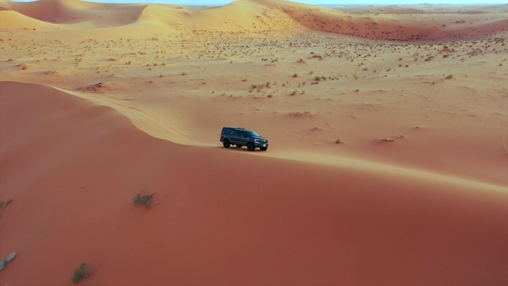 سيارة دفع رباعي على كثبان النفود الكبير في حائل، لقطة جوية.