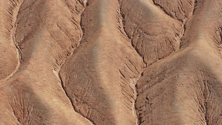تضاريس جبلية جافة بنمط متموج، لقطة جوية.