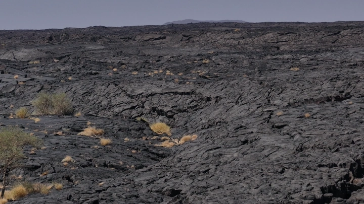 منظر للحمم البركانية المتجمدة في الصحراء، لقطة نهارية.