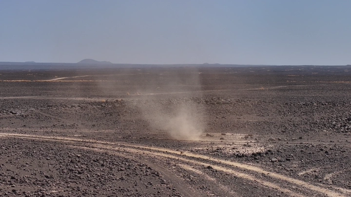 عاصفة رملية صغيرة في صحراء قاحلة، لقطة من الأرض.
