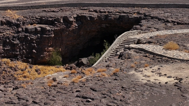 كهف في منطقة صخرية مع مسار حجري، تصوير نهاري.