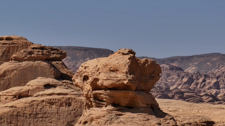 تكوينات صخرية في العلا تحت سماء زرقاء، لقطة نهارية.