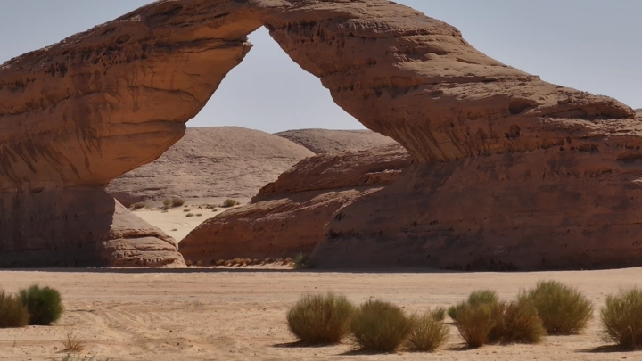قوس صخري في العلا تحت ضوء الشمس، لقطة نهارية.