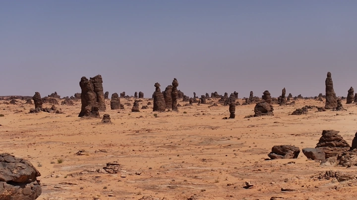 تكوينات صخرية في صحراء الغراميل تحت سماء صافية، لقطة بانورامية.