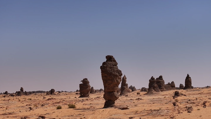 تكوينات صخرية في صحراء الغراميل تحت سماء زرقاء، لقطة نهارية.