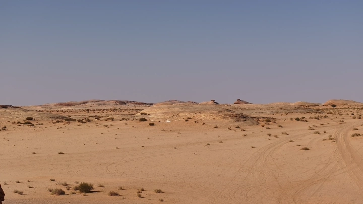 صحراء واسعة مع تلال صخرية في الأفق، لقطة بانورامية.