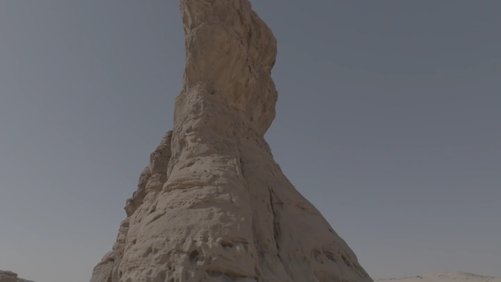 تكوين صخري في العلا تحت سماء صافية، لقطة من الأسفل.