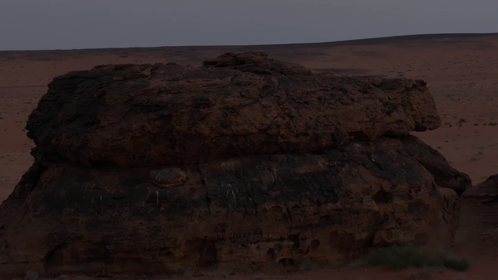 صخرة كبيرة في صحراء عند الغروب، لقطة بانورامية.