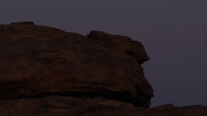 صخرة كبيرة في الليل تحت ضوء القمر، منظر جانبي للقمر.