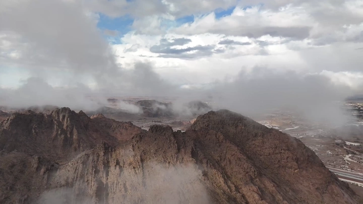 لقطة جوية لغيوم فوق جبال الرعيلة حائل أثناء المطر، تصوير درون.