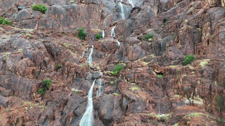 Small waterfalls on the mountains of Jouf Hail during the rain, aerial shot.