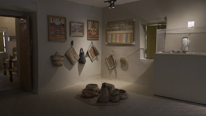 غرفة تقليدية مزينة بأعمال فنية، إضاءة دافئة، تصوير داخلي.