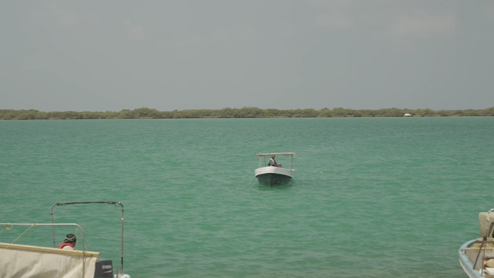 قارب صيد في بحيرة هادئة، لقطة نهارية.